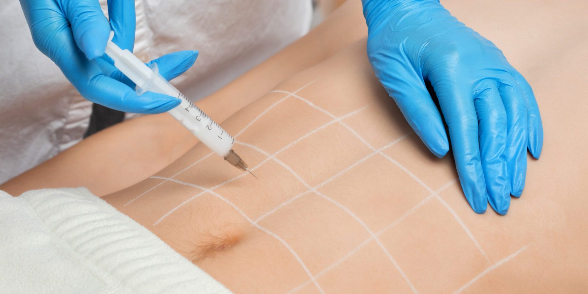 Cropped photo of a professional female dermatologist administering a fat-dissolving injection into her patients abdomen